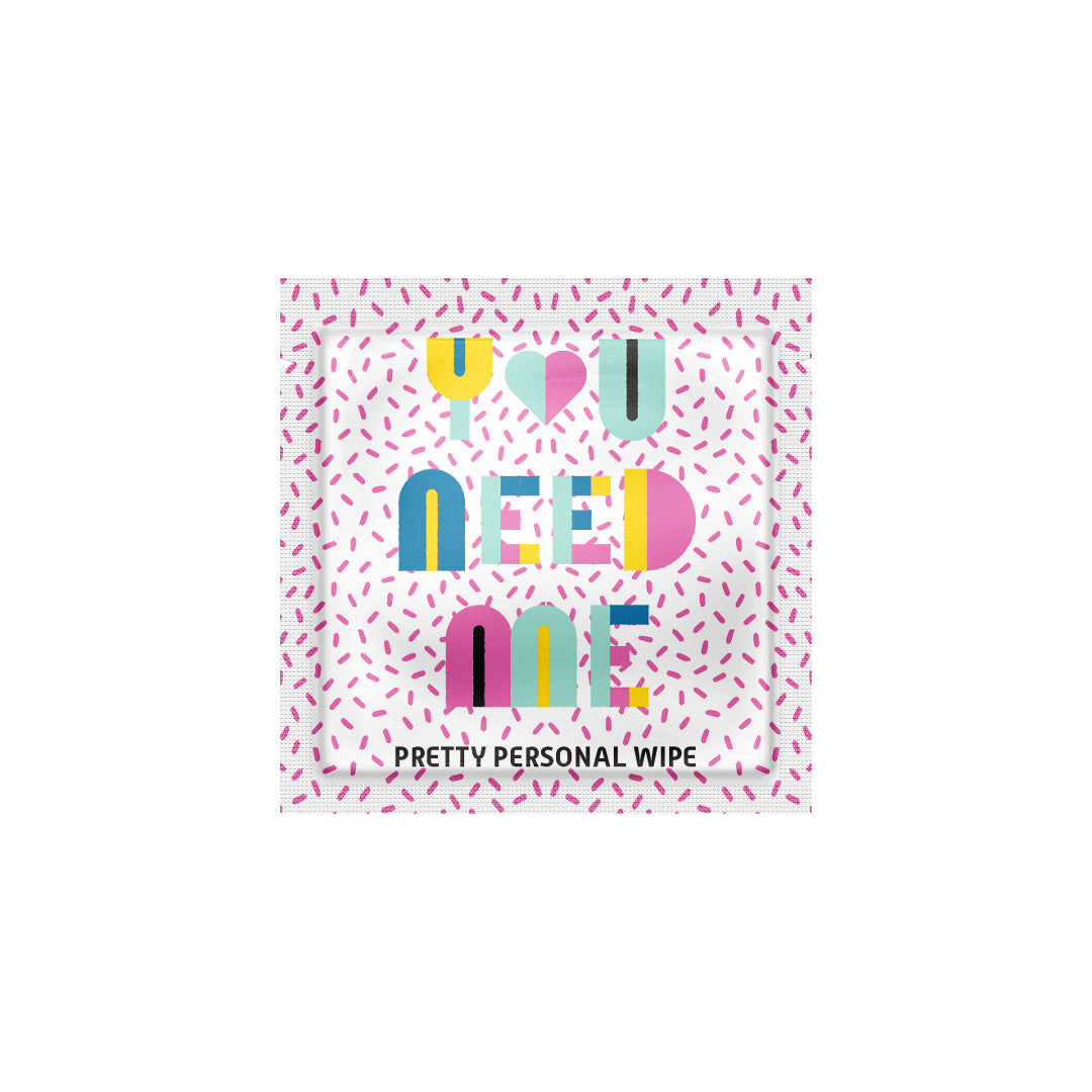 Personal wipe packaging with colorful text and a pink pattern on a white background